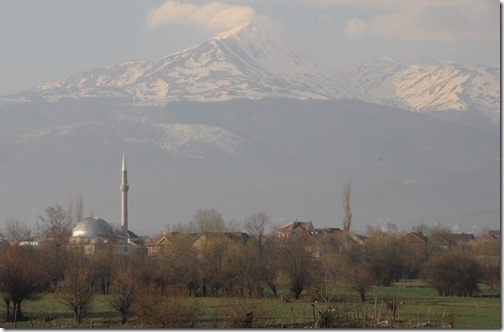 View of the Šar (Sharr) Mountains and a village mosque from a train traveling through the Kosovo countryside.